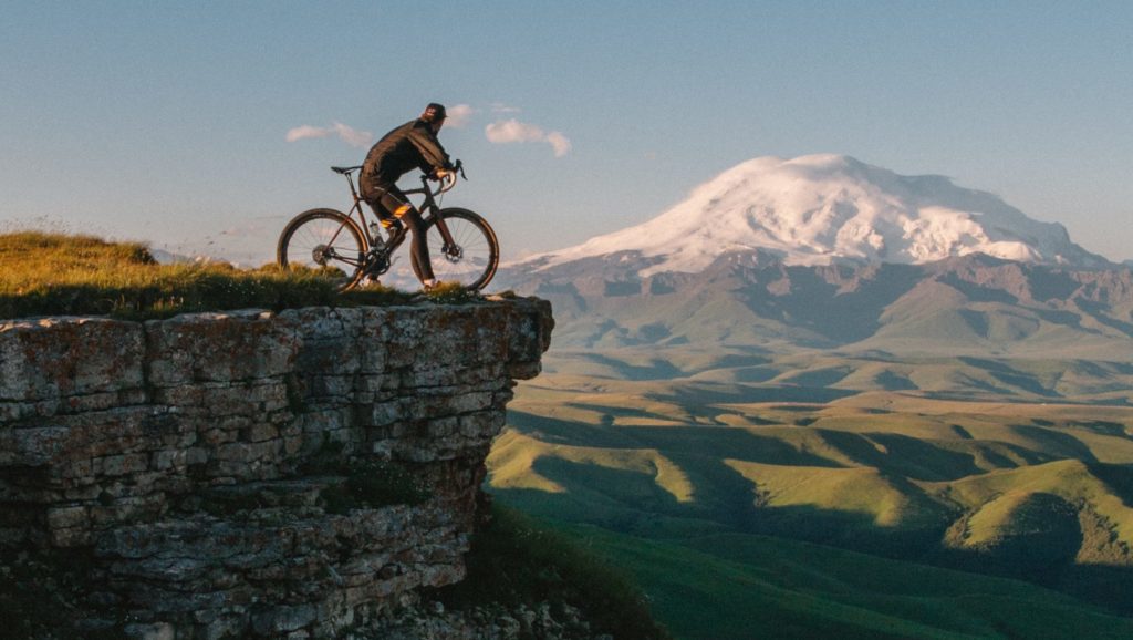 Picture of a cyclist in the mountains, resembling the purpose of the Biodiscovery Platform to discover new microbial talent under specific conditions (e.g. high altitude in cycling)